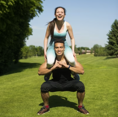 Woman on Man's shoulders working out in the park